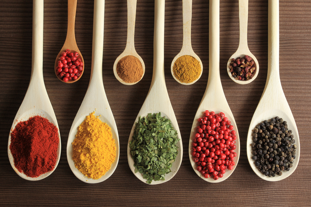 Various spices on wooden spoons