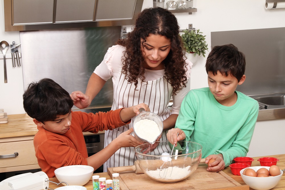 Woman and two children baking