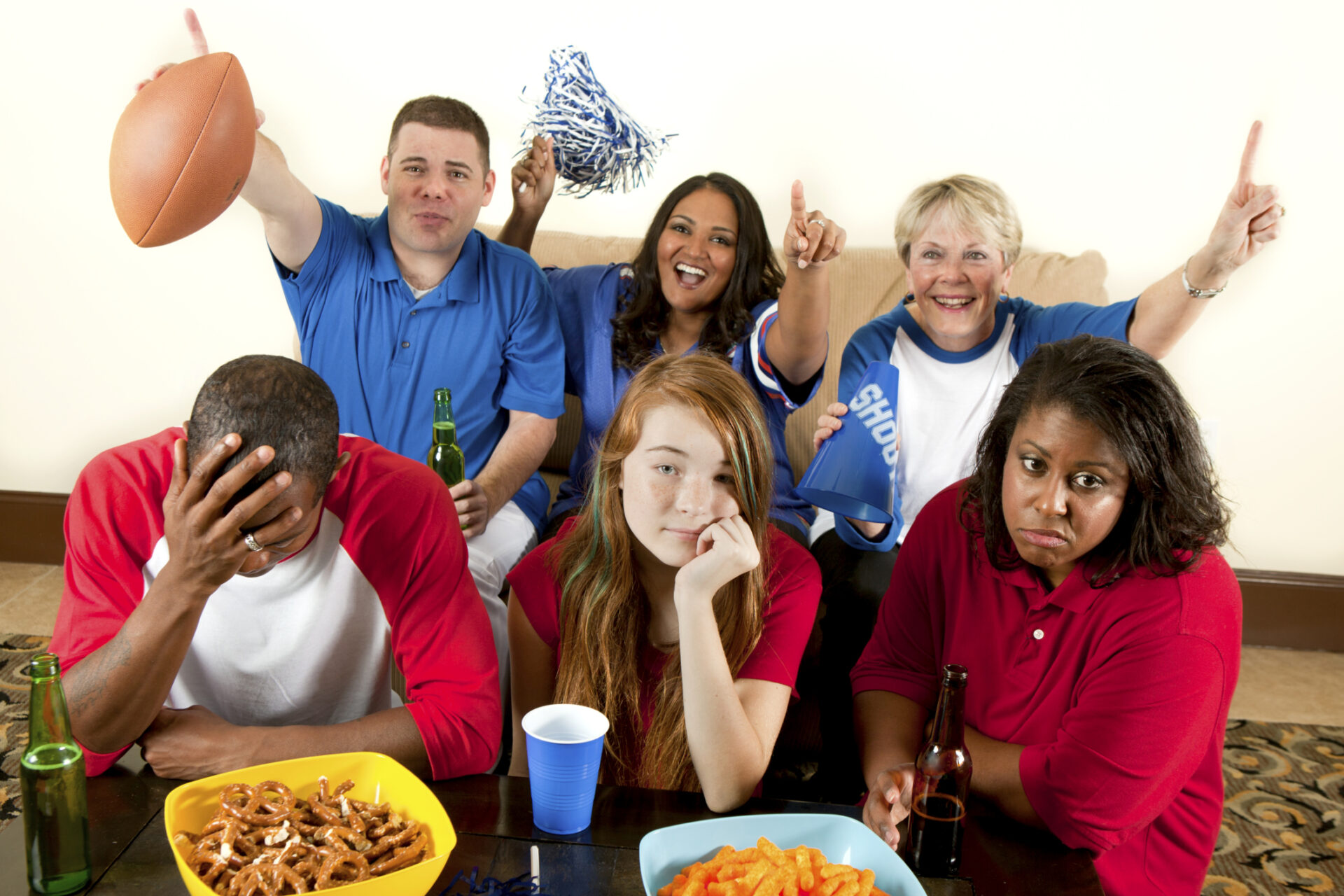 Group of friends watching a football game with snacks