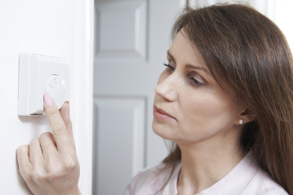 Woman using thermostat