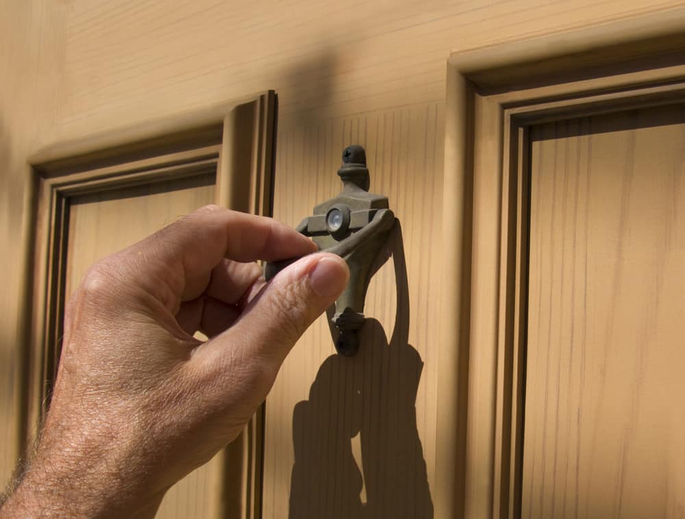 Man's hand using door knocker