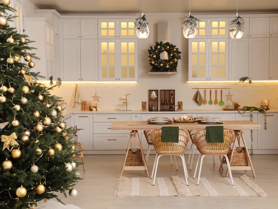 Picture of a beautiful white kitchen with a lit Christmas tree and wreath